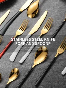 Close-up view of a gold stainless steel cutlery set with red, white and black matte handles