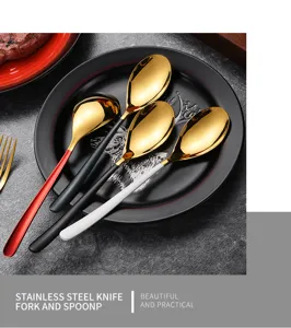 Close-up of four gold stainless steel spoons with colored handles on a black plate.
