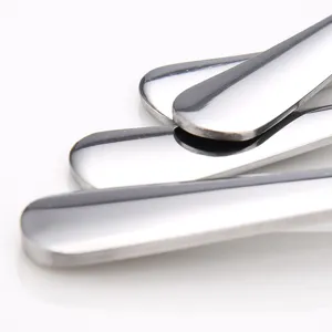 Close-up of mirror-polished stainless steel dessert spoons on white background