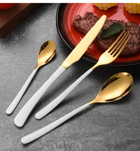 Detailed view of moonlight gold stainless steel cutlery set with elegant white handles