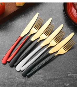 Close-up detail of gold stainless steel knives and forks with colorful matte handles
