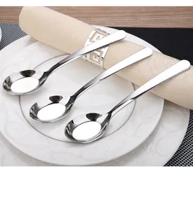 Detailed view of three polished 304 stainless steel flat bottom soup spoons on a plate.