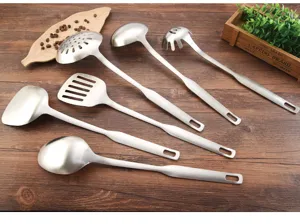 Professional stainless steel kitchen utensil set with ladles and spatulas on wood table