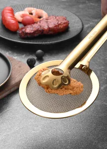 Detail of gold 304 stainless steel paw-shaped frying tong filtering oil from fried chicken