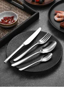 Elegant detailed macro view of 4-piece stainless steel cutlery set on a textured black plate