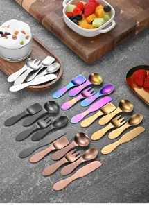 Multi-colored stainless steel mini dessert spoons and forks set on a stone surface.