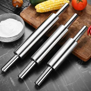 Set of three professional stainless steel rolling pins on a wooden kitchen counter