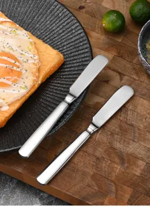 High-quality forged stainless steel butter knives displayed on a rustic wooden board