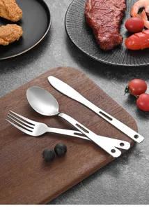 Close-up of stainless steel 3-piece camping cutlery set with hollow handles on wood