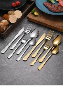 Detailed macro view of retro floral relief on silver and gold stainless steel cutlery set