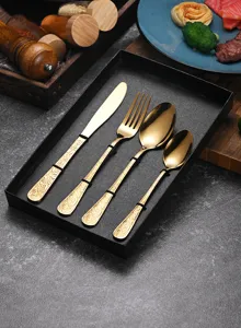 Macro view of gold stainless steel cutlery set featuring elegant floral relief engraving
