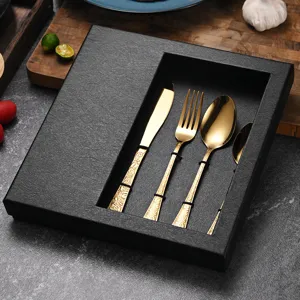 Luxury gold embossed stainless steel cutlery set in a black gift box for elegant fine dining.