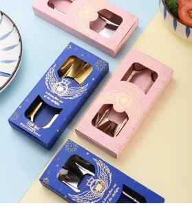 Detailansicht von Edelstahlschaufellöffeln in eleganten blauen und rosa Geschenkkartons.