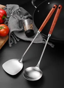 Close-up detail of stainless steel soup ladle and spatula with ergonomic wood handles
