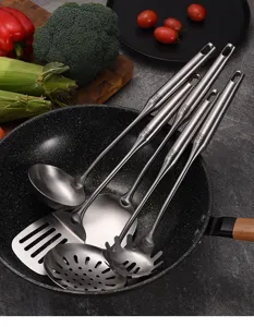 Detailansicht von Küchenutensilien aus Edelstahl 304 in einem Wok mit frischem Gemüse