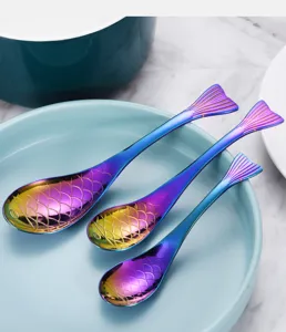 Detail von drei kreativen fischförmigen Löffeln aus schillerndem Regenbogen-Edelstahl