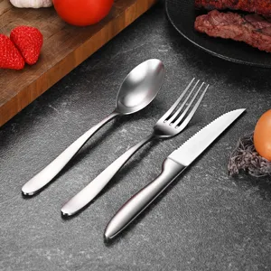 Brushed stainless steel cutlery set with a serrated steak knife, a dinner fork, and a spoon.