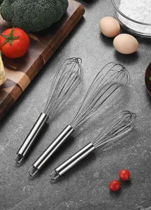 Juego profesional de tres batidores de acero inoxidable sobre una encimera de cocina gris