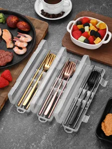 Detail of portable cutlery sets in transparent cases with gold and rose gold finishes.