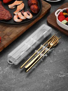 Detail of gold portable cutlery set with fork, spoon, chopsticks and clear case