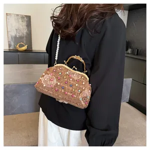 Vista dettagliata di una pochette da sera marrone con perline floreali e tracolla di perle