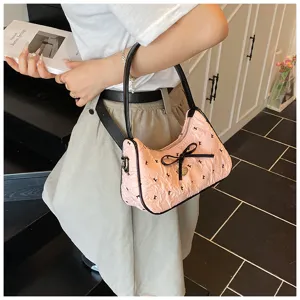 Stylish pink crescent hobo bag with black bow detail and chic K-pattern print