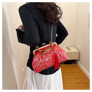 Detaillierte Ansicht einer roten bestickten Abendtasche mit Bambusgriff und Quaste