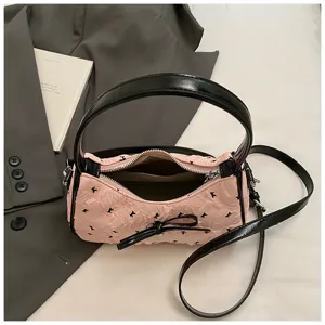 Close-up of pink crescent bag with black bow detail and open zipper interior pocket