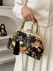 Sac à main élégant brodé de fleurs avec poignée en bambou et pompon noir pour soirée.