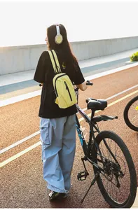 Close-up of a vibrant yellow nylon crossbody chest bag worn during an outdoor cycling trip