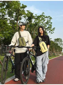 Detail of couple wearing nylon cycling chest bags in an outdoor park setting.