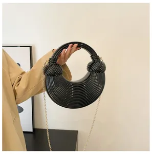 Detail view of a glossy black acrylic crescent bag featuring chic horizontal stripes