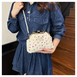 Dettaglio di una borsa bianca con perle colorate e tracolla di perle eleganti