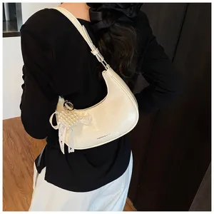 Rückansicht cremefarbene Hobo-Tasche mit Perlenherz-Anhänger als Unterarmtasche
