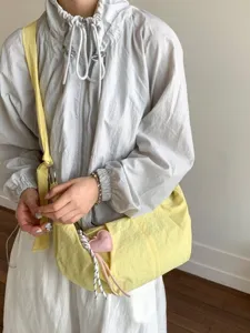 Trendige hellgelbe Nylon-Umhängetasche mit Herzanhänger-Accessoire für den Sommer