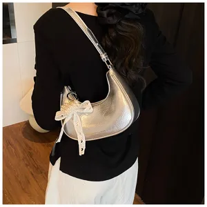 Silberne Metallic-Hobo-Tasche mit Perlenspitzen-Schleife als Achseltasche getragen