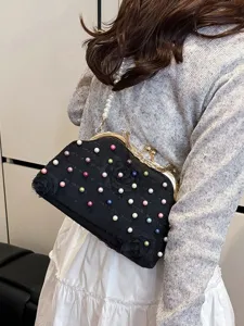 Elegante pochette da sera nera con perle colorate e accenti floreali indossata dalla modella