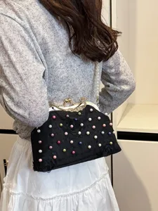 Elegante pochette da sera floreale nera con perle colorate e tracolla su una modella