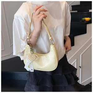 Detailansicht der cremefarbenen Schultertasche aus Knautschleder mit Perlenherz-Anhänger