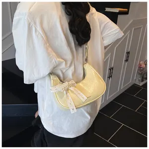 Gelbe halbmondförmige Achseltasche aus Ölleder mit Perlenherz und feinem Schleifendetail