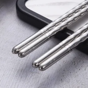 Anti-slip stainless steel chopsticks with textured screw handles for kitchen dining.