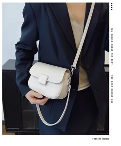 Model wearing a vintage cream white crossbody bag with woven texture and a flap cover.