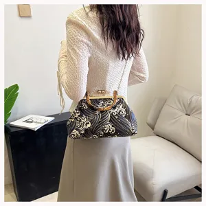 Vista detallada del elegante bolso de noche bordado con patrón de olas y cadena