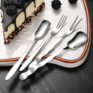 Creative stainless steel dessert cutlery set with unique wavy handles on white plate