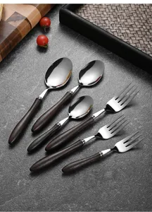 Close-up of stainless steel cutlery set with elegant dark chicken wing wood handles