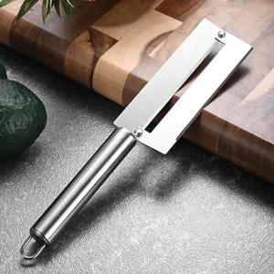 Stainless steel pineapple and sugarcane peeler kitchen tool placed on a wooden board