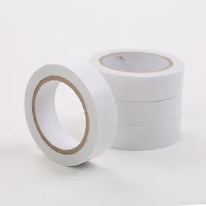 Primo piano di rotoli di nastro biadesivo bianco con anima in carta e finitura pulita.