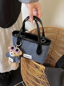 Stylish denim blue bucket handbag for women featuring a cute teddy bear charm accessory