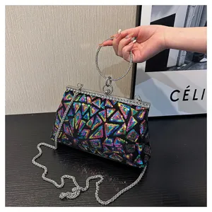 Vue détaillée d'une main tenant une pochette à paillettes colorée avec chaîne et anneau.