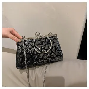 Gros plan d'un sac de soirée à paillettes avec poignée anneau en strass.